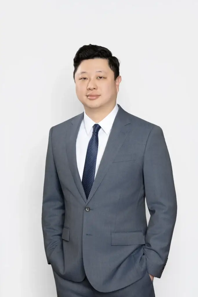 Nathan Sudarma, partner attorney at Uzoma Sudarma, a Sugar Land, Texas personal injury and estate law firm, in a full-length portrait wearing a gray suit.