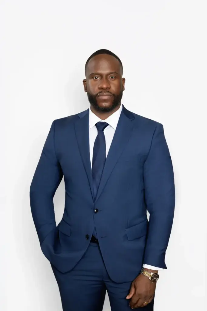 Chester Uzoma, partner at Uzoma Sudarma, a Sugar Land, Texas personal injury and estate law firm, in a full-length portrait wearing a navy suit.